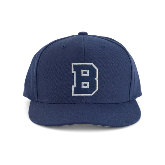 The Boeing Varsity Snapback Hat from The Boeing Store features a large white letter B outlined in black on navy blue, classic aviation style, and an adjustable snapback closure, displayed against a plain white background.