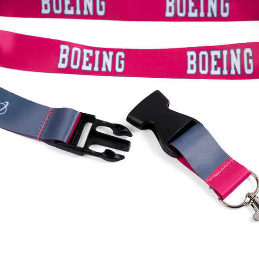 Close-up of two Boeing Varsity Pink Lanyards by Boeing, featuring a white logo and detachable buckle. One lanyard is unbuckled, showing a black clasp and metal clip, while the other lies flat displaying the varsity logo.