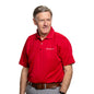 Male model wearing the Mesh tech polo in red color tucked in grey pants and brown belt.