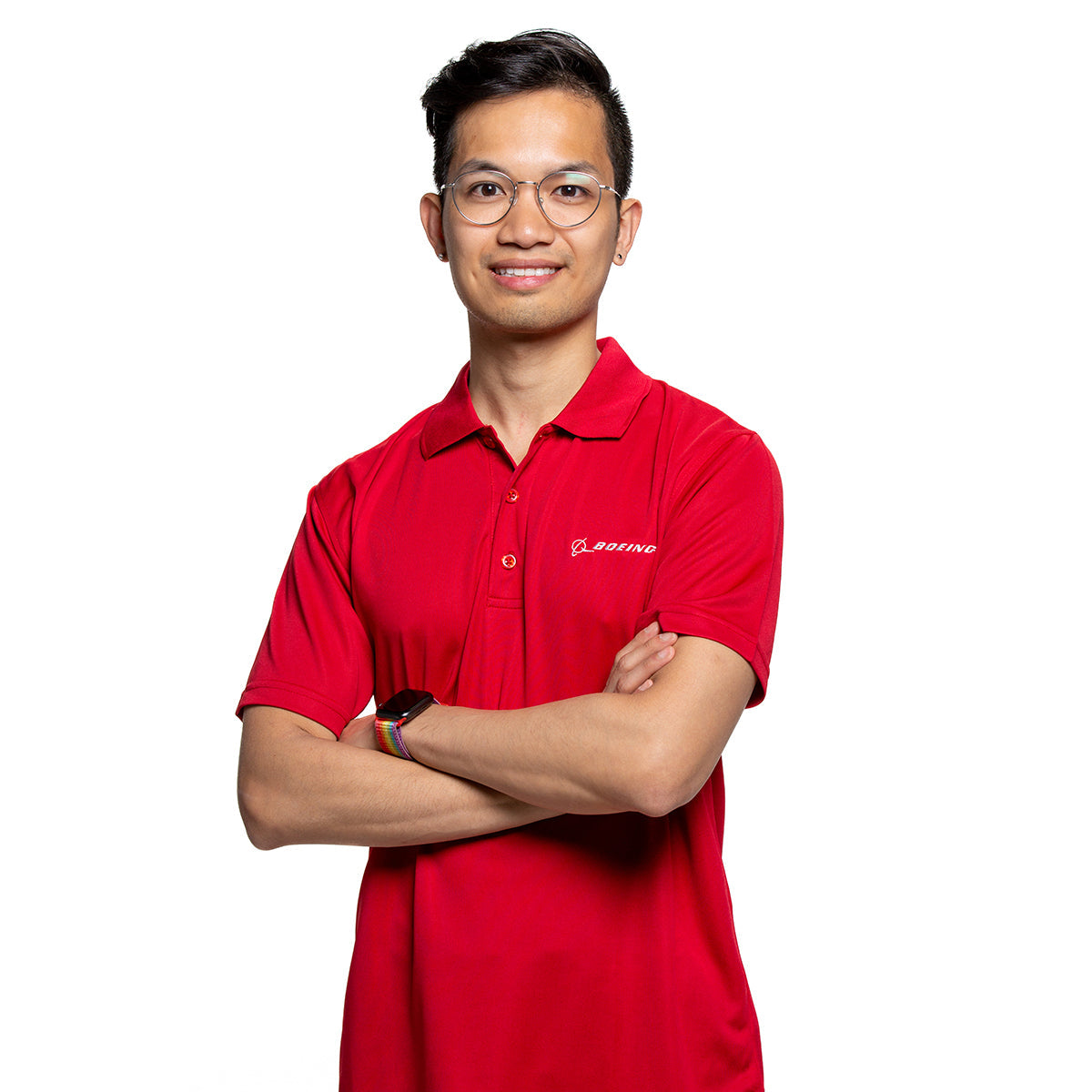 Male model with mesh tech polo in red.  Arms crossed with rainbow band watch.