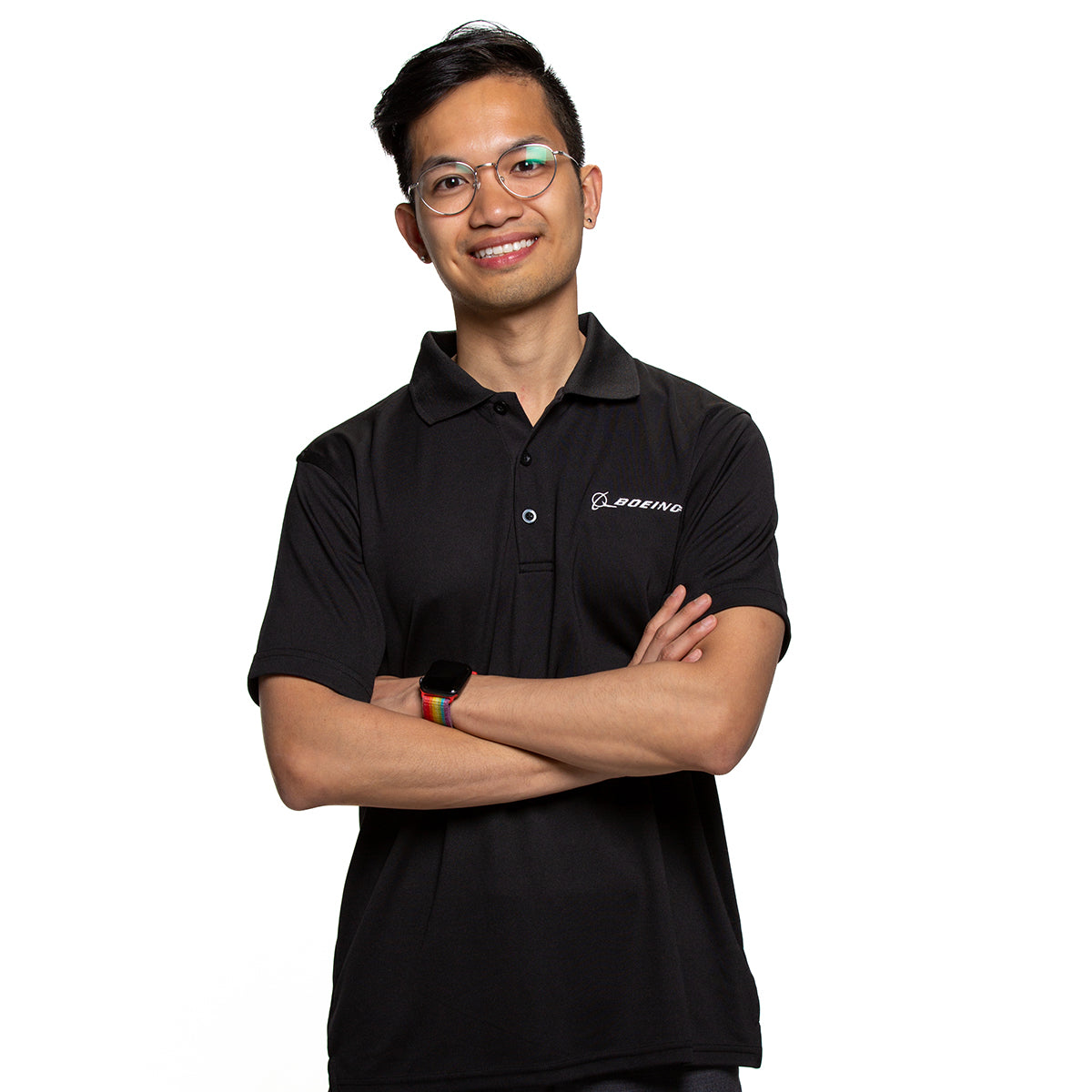 Male model with mesh tech polo in black.  Arms crossed with rainbow band watch.