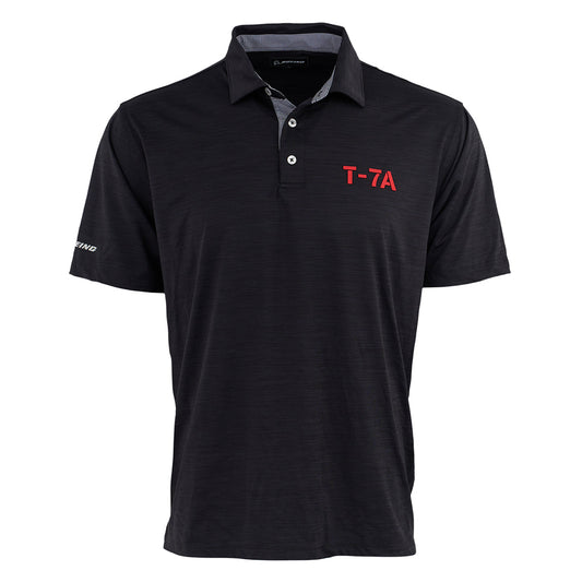 The Boeing T-7A Red Hawk Series Men’s Polo by BOEING is a black short-sleeve polo with a collar, three buttons, “T-7A” in red on the left chest, “Boeing” on the right sleeve, UPF 50 sun protection, and a subtle textured pattern.