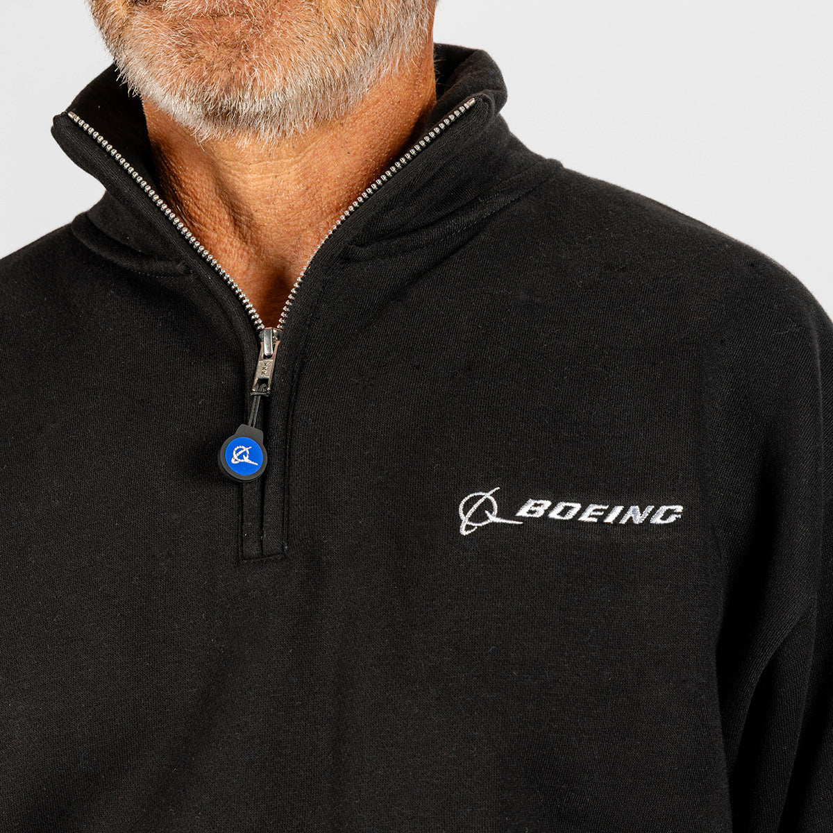 A man with a grey beard wears a Boeing Unisex Ultra Soft Quarter-Zip by BOEING in black, featuring the logo and a blue circular pin on the zipper; only his lower face, neck, and upper torso are visible.