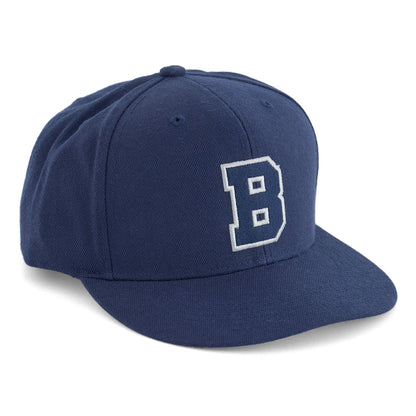The Boeing Store’s Boeing Varsity Snapback Hat is navy blue with a large white outlined “B” on the front, classic aviation styling, and a convenient snapback closure.