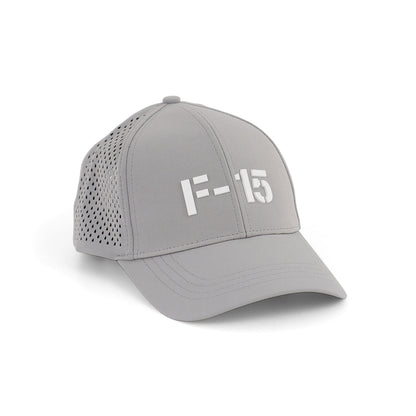 The Boeing F-15 Eagle Series Hat by BOEING is a light gray baseball cap with perforated side panels and F-15 in bold white letters on the front, shown at an angle against a white background.