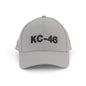 The BOEING KC-46A Pegasus Series Hat is a light gray baseball cap with a bold 3D KC-46 logo on the front and an adjustable velcro closure for comfort, shown facing forward against a white background.