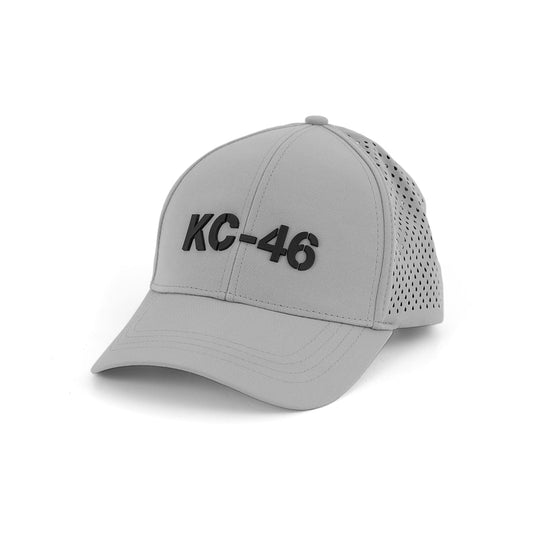 The Boeing KC-46A Pegasus Series Hat by BOEING is a light gray baseball cap featuring a bold black 3D KC-46 logo on the front and perforated back panels, shown on a white background.