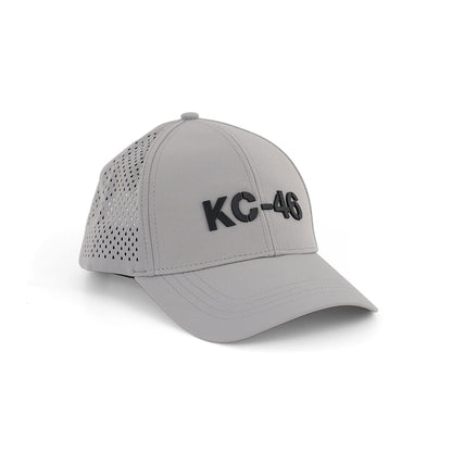 The Boeing KC-46A Pegasus Series Hat by BOEING is a light gray baseball cap with a raised black 3D KC-46 logo on the front and perforated side panels for breathability.