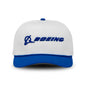The Boeing Signature Two Tone Performance Rope Hat by BOEING is white with a blue brim and button, features the blue embroidered Boeing logo on front, and is made from recycled polyester for moisture-wicking comfort.
