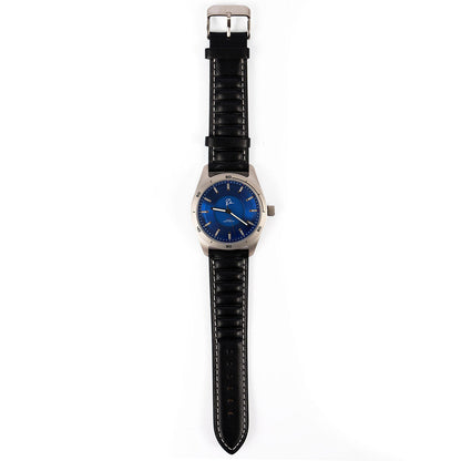 The Boeing Store’s Boeing Symbol Men's Solar Watch 42 mm features a round blue face, silver case, and black leather strap with white stitching. It uses Japanese solar movement and displays 8:19 on a white background.