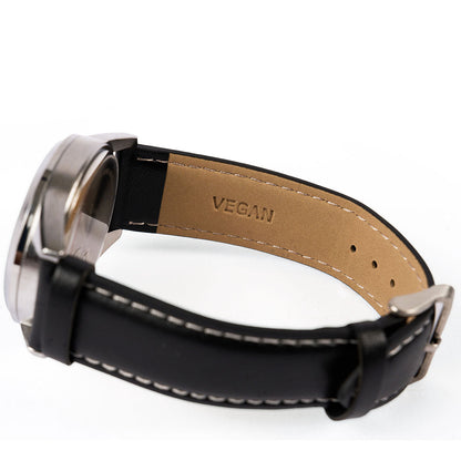 A close-up of the Boeing Symbol Mens Solar Black Watch 42 mm by The Boeing Store. Its black strap with white stitching has a tan VEGAN-stamped lining, and it features a Japanese solar movement for reliable performance.
