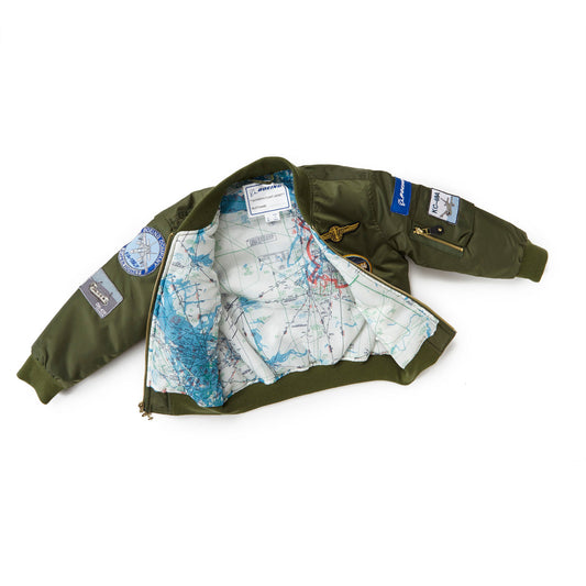The Boeing Stores Boeing Kids Green Flight Jacket is perfect for aviation fans, featuring vintage-look patches on the sleeves and front. Made from durable nylon, the interior reveals a printed world map design lining.