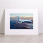 Bring the beauty of aviation to your space with the Boeing 737-10 Matted Print - Small from Boeing, featuring a high-resolution image of a Boeing airplane soaring above snow-covered mountains at sunrise. This professionally matted print includes the official Boeing logo embossed below the image.
