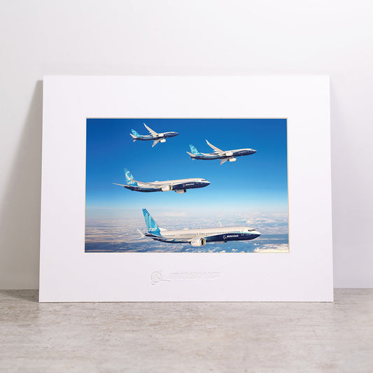 A Boeing 737 MAX Family Sky Matted Print - Large showing three airplanes flying in formation over a landscape under a clear blue sky.