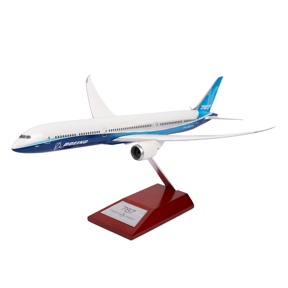The Boeing Unified 787-10 Dreamliner 1:200 Model by The Boeing Store is displayed on a wooden stand, featuring its sleek white and blue design with a visible engine and unique wing shape. This model embodies the elegance and innovation of the renowned 787 family.