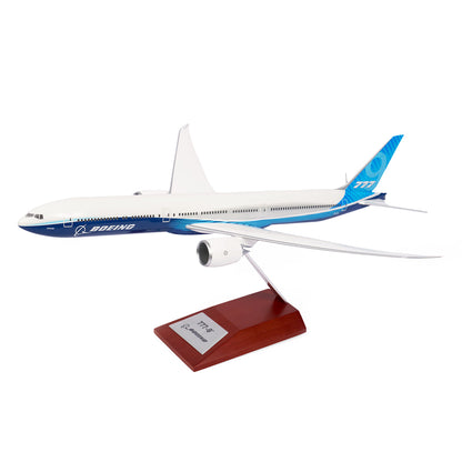 The Boeing Stores Boeing Unified 777-9 1:200 Model showcases a blue and white sleek design on a wooden base with a plaque featuring 777X and Boeing branding, making it ideal for aviation enthusiasts. It highlights detailed wings and engines as a prized piece of memorabilia.
