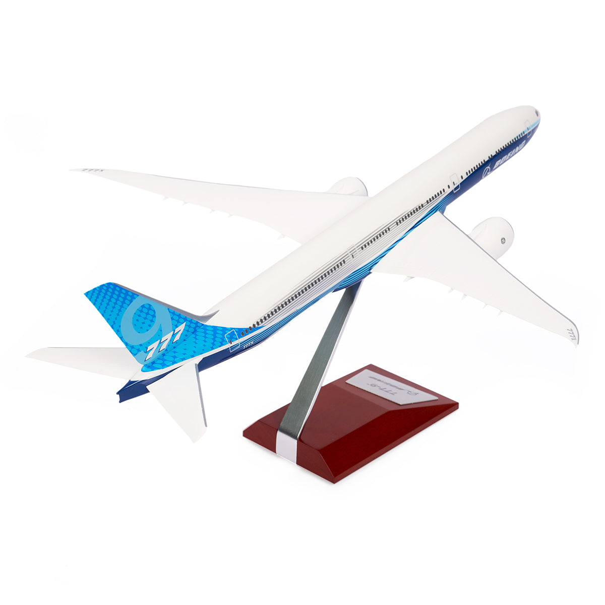 The Boeing Stores Boeing Unified 777-9 1:200 Model, featuring a white body with blue accents and a stylized tail design, is showcased on a sleek stand against a plain white background, delighting aviation enthusiasts and collectors of Boeing memorabilia.