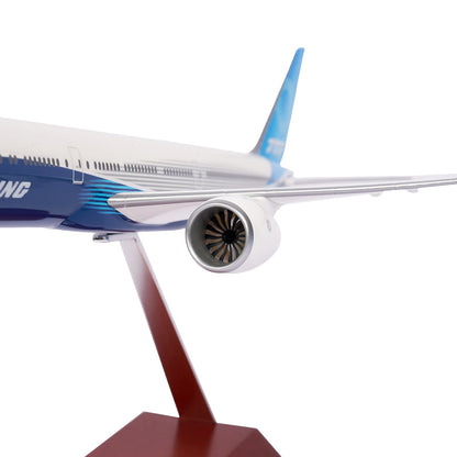 The Boeing Unified 777-9 1:200 Model from The Boeing Store features a close-up view of the wing, fuselage, and engine on a brown stand. With its sleek white and blue design, its perfect for aviation enthusiasts and collectors of Boeing memorabilia.