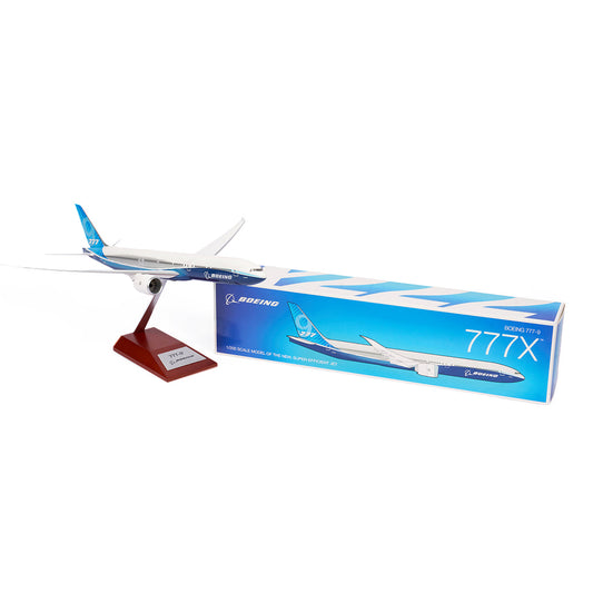 The Boeing Stores Boeing Unified 777-9 1:200 Model is a must-have for aviation fans, featuring a striking display on a stand next to its blue and white packaging. The box highlights the aircrafts image and branding, making it an essential piece of Boeing memorabilia.