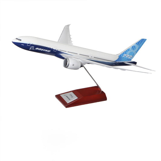 The Boeing Stores 1:200 Boeing Unified 777-8 Plastic Model, mounted on a metal rod with a wooden base, is ideal for aviation enthusiasts. It showcases the iconic Boeing house colors, with its white body, blue accents, and 777-8 model insignia elegantly displayed at the rear.