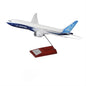 The Boeing Stores 1:200 Boeing Unified 777-8 Plastic Model, mounted on a metal rod with a wooden base, is ideal for aviation enthusiasts. It showcases the iconic Boeing house colors, with its white body, blue accents, and 777-8 model insignia elegantly displayed at the rear.
