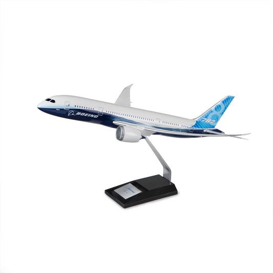 The Boeing Store’s Boeing 787-8 Dreamliner Plastic 1:144 Model features blue and white livery and is displayed on a metal stand, highlighting the jetliner’s advanced composite materials and fuel efficiency.