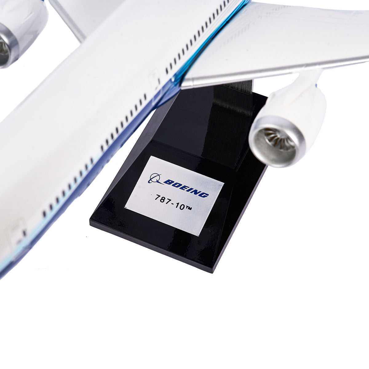 A close-up of the Pacific Miniatures Boeing Unified 787-10 Dreamliner Plastic 1:144 Model shows its fuselage, wing, and engine details as it sits on a black stand.
