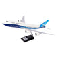 The Boeing Stores Boeing Unified 747-8i 1:144 Model features blue and white livery, a black stand with nameplate, and detailed engines and tail fin—perfect for fans of high-capacity aircraft.