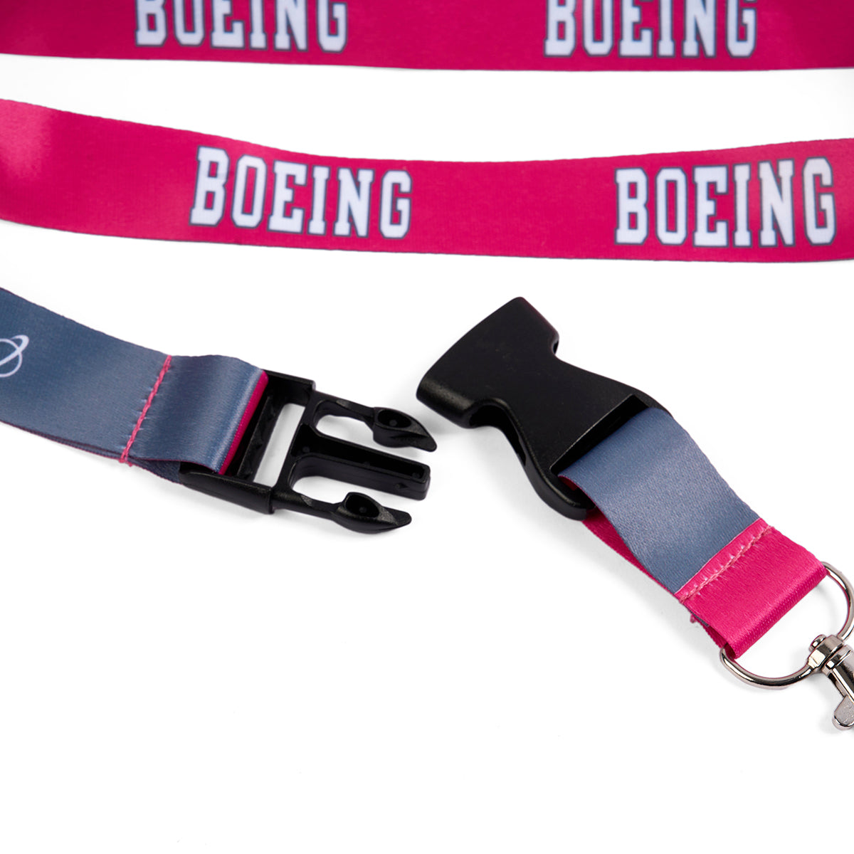 Close-up of two Boeing Varsity Pink Lanyards by Boeing, featuring a white logo and detachable buckle. One lanyard is unbuckled, showing a black clasp and metal clip, while the other lies flat displaying the varsity logo.