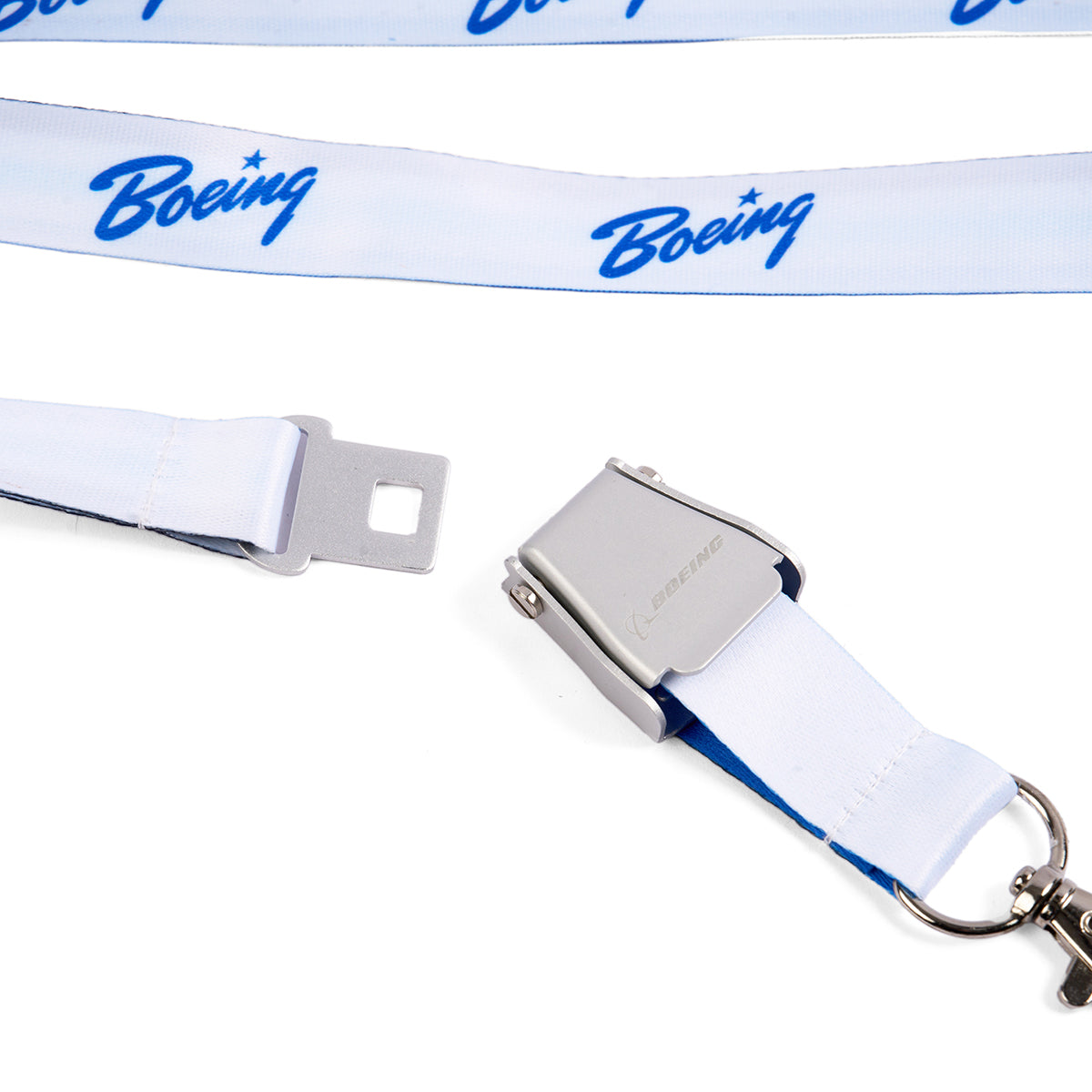 The Boeing Heritage Script Blue Seat Belt Buckle Lanyard features a durable white polyester strap, blue script logo, and a metal seatbelt-style buckle clasp. The Boeing-branded lanyard is shown unclasped on a white background.