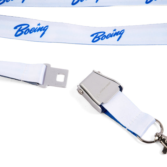 The Boeing Heritage Script Blue Seat Belt Buckle Lanyard features a durable white polyester strap, blue script logo, and a metal seatbelt-style buckle clasp. The Boeing-branded lanyard is shown unclasped on a white background.