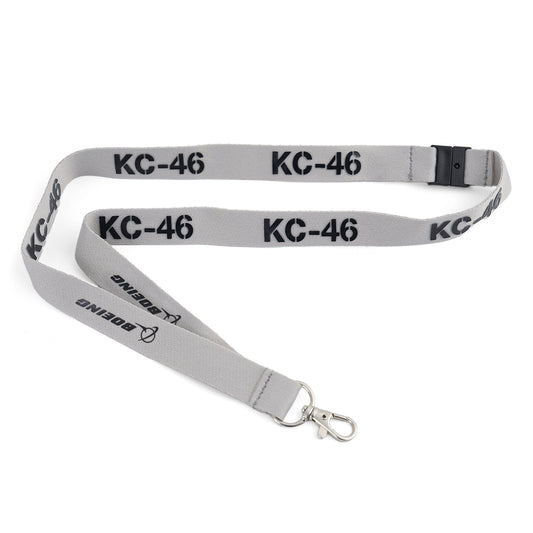 The Boeing KC-46A Pegasus Series Lanyard by BOEING is a gray aviation lanyard with a metal clip, featuring “KC-46” and the Boeing logo in black along its length.