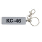 The BOEING KC-46A Pegasus Series Keychain features a gray rectangle with black KC-46 text, attached to a metal keyring and silver lobster clasp—ideal for aviation enthusiasts or Boeing fans.