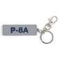 The Boeing P-8A Poseidon Series Keychain by BOEING is a gray PVC rectangular keychain with raised dark blue P-8A text, attached metal key ring, and lobster clasp—ideal for aviation enthusiasts.