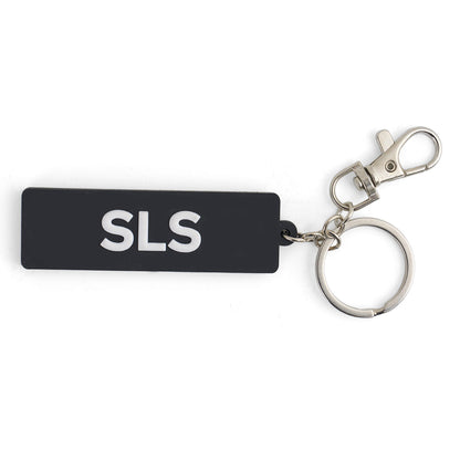 The BOEING Space Launch System Series Keychain features a black rectangular PVC design with white SLS lettering, a silver keyring, and metal clasp—an ideal accessory for aviation enthusiasts.