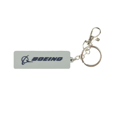 A rectangular PVC Boeing 767 Series Keychain by BOEING, featuring a metal ring and clasp, showcases the BOEING logo and name in blue on a white background—an ideal accessory for aviation enthusiasts and collectors.