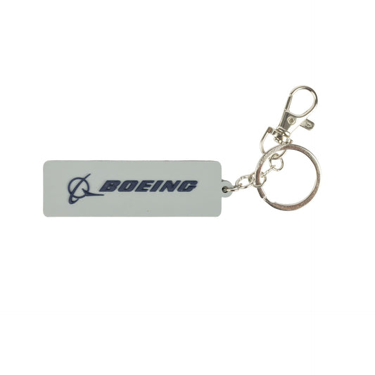 A rectangular PVC Boeing 767 Series Keychain by BOEING, featuring a metal ring and clasp, showcases the BOEING logo and name in blue on a white background—an ideal accessory for aviation enthusiasts and collectors.