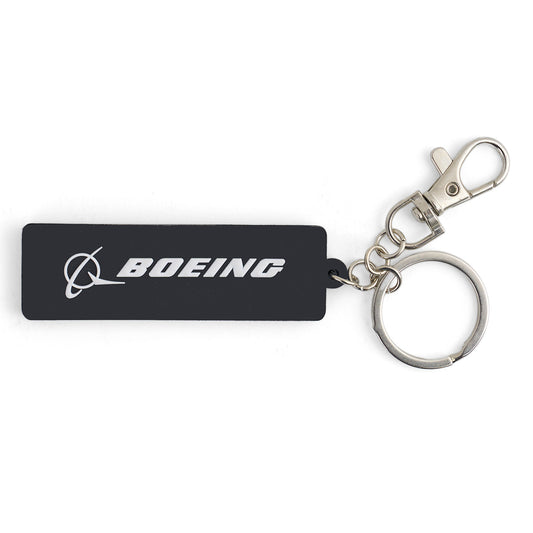 The Boeing AH-64 Apache Series Keychain by BOEING features a black rectangle with a white logo and text, attached to a metal key ring and lobster clasp—ideal for aviation enthusiasts or fans of the iconic AH-64.