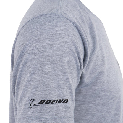 A person wearing the Boeing P-8A Poseidon Series Unisex T-Shirt in heather gray, featuring moisture-wicking fabric and a black BOEING logo on the left sleeve—a great choice for aviation enthusiasts.