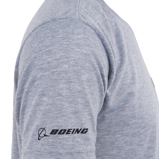A person wearing the Boeing P-8A Poseidon Series Unisex T-Shirt in heather gray, featuring moisture-wicking fabric and a black BOEING logo on the left sleeve—a great choice for aviation enthusiasts.