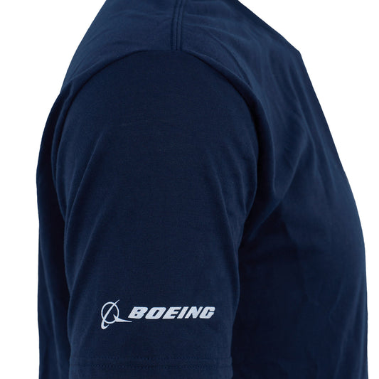 A close-up of an aviation fan in a navy Boeing 737 Series Unisex T-Shirt by BOEING, featuring white BOEING logo and name printed on the sleeve. Moisture-wicking fabric keeps them comfortable.
