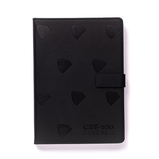 The Boeing CST-100 Starliner Notebook by The Boeing Store is a black PU hardcover with embossed triangular patterns, a right-side clasp, and the text CST-100 STARLINER elegantly embossed in the bottom right corner, all on a sleek plain white background.